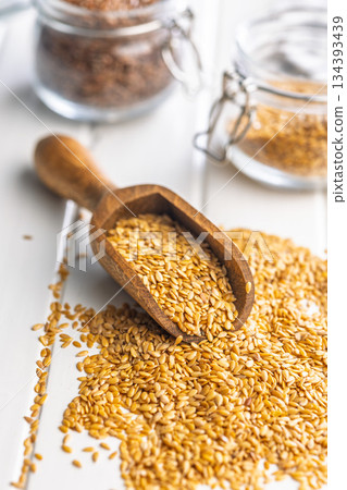Golden linseed or flaxseed. Healthy flax seed in scoop on white table. 134393439