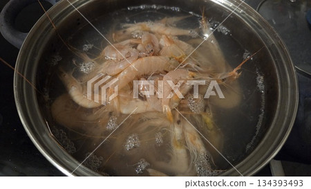 Cooking shrimps in a pot of boiling water for seafood meal preparation 134393493