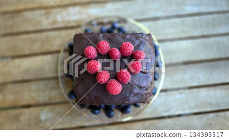 Delicious homemade chocolate cake with raspberries and blueberries for dessert. Top view. World Cake Day 134393517