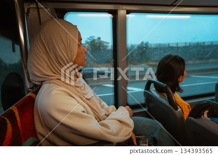 Two Young Women Enjoying Their Journey on a Bus with a Scenic Window View Two Young Women Enjoying Their Journey on a Bus with a Scenic Window View 134393565