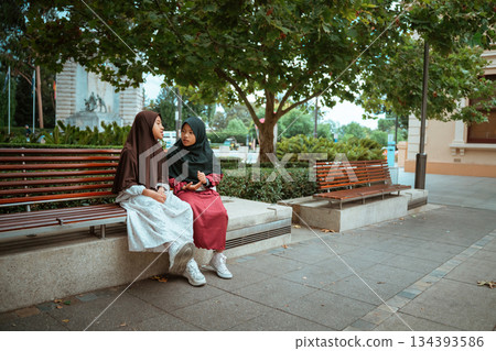 Friends are enjoying a lively conversation in a beautiful park Friends are enjoying a lively conversation in a beautiful park 134393586