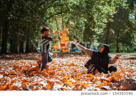 A Joyous Autumn Day A Child and Parent Play with Colorful Leaves 134393590