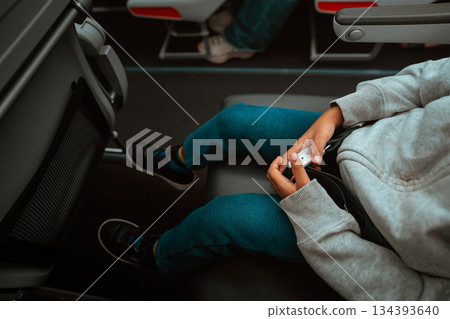 A Child Engaged in Playing with a Game Controller While on an Airplane Seat A Child Engaged in Playing with a Game Controller While on an Airplane Seat 134393640