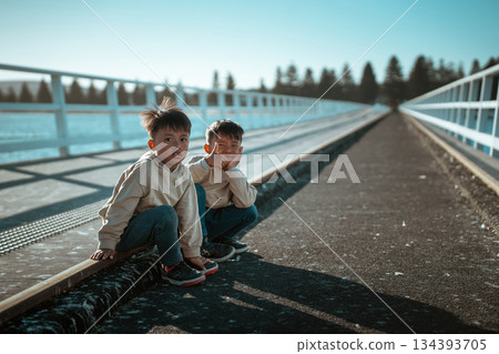 Joyful Moments Kids Happily Playing on a Beautiful Scenic Bridge, Filled with Laughter and Joy Joyful Moments Kids Happily Playing on a Beautiful Scenic Bridge, Filled with Laughter and Joy 134393705