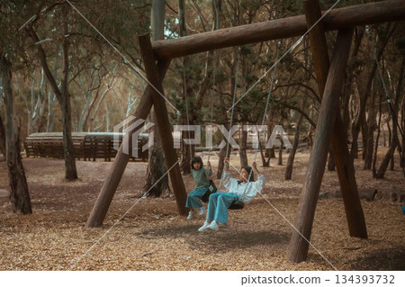Enjoying Playful Moments in a Beautifully Serene Forest Setting Featuring a Swing Enjoying Playful Moments in a Beautifully Serene Forest Setting Featuring a Swing 134393732