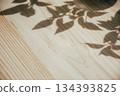shadows of plants on a wooden table, minimalistic background 134393825