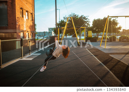 A Joyful Child Swinging Happily in the Playground During a Beautiful Sunset Evening A Joyful Child Swinging Happily in the Playground During a Beautiful Sunset Evening 134393840
