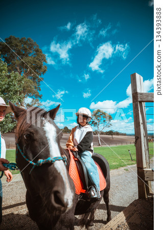A Child Joyfully Riding a Pony on a Beautiful Bright Sunny Day A Child Joyfully Riding a Pony on a Beautiful Bright Sunny Day 134393888