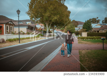 A Peaceful Mother and Her Child Enjoying a Serene Walk in the Neighborhood 134393900