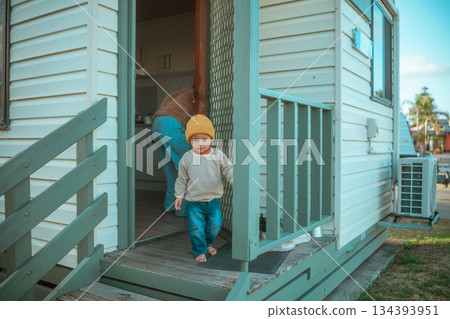 caucasian toddler in warm clothing ventures out of caravan into peaceful outdoor setting caucasian toddler in warm clothing ventures out of caravan into peaceful outdoor setting 134393951