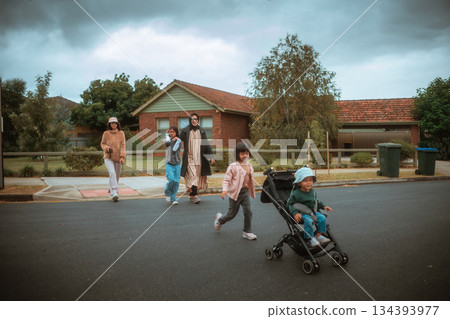Family Strolling Through Neighborhood with Children on a Cloudy Day Family Strolling Through Neighborhood with Children on a Cloudy Day 134393977