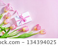 spring card, tulips and gift with pink ribbon on pink background, mother's day 134394025