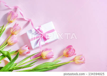 spring card, tulips and gift with pink ribbon on pink background, mother's day spring card, tulips and gift with pink ribbon on pink background, mother's day 134394025
