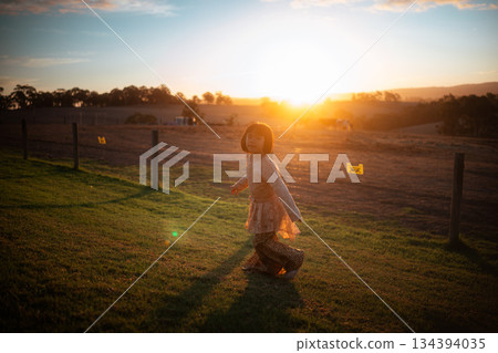 A Joyful Girl is Dancing at Sunset in a Beautiful Scenic Field of Grass A Joyful Girl is Dancing at Sunset in a Beautiful Scenic Field of Grass 134394035