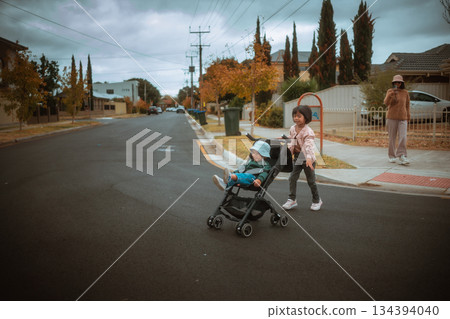 Children and Stroller on a Quiet Residential Street in Autumn 134394040