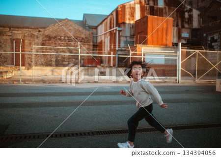 A Happy Child Joyfully Running and Playing Outdoors in a Colorful Urban Setting Full of Life A Happy Child Joyfully Running and Playing Outdoors in a Colorful Urban Setting Full of Life 134394056