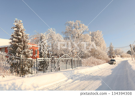 Russian village in winter, Christmas background. After a snowfall, tree branches are covered with snow and sparkle in the sun, in severe frost and low temperatures. This is a beautiful winter banner, 134394308