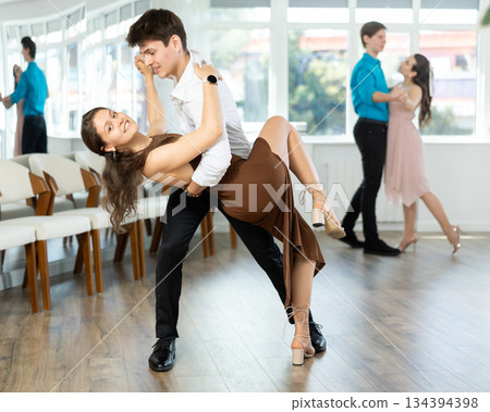 Latin American guy and girl performing kizomba in dance studio Latin American guy and girl performing kizomba in dance studio 134394398