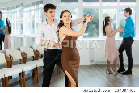 During rehearsal, guy and girl participants of dance workshop perform social pair dance During rehearsal, guy and girl participants of dance workshop perform social pair dance 134394403