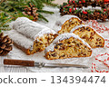 Stollen with filling of raisins, candied fruit 134394474
