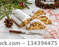 Stollen with filling of raisins, candied fruit 134394475