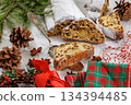 Stollen with filling of raisins, candied fruit 134394485