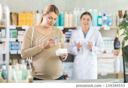 Pregnant woman buyer scans pills qr code with woman pharmacist Pregnant woman buyer scans pills qr code with woman pharmacist 134394553