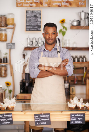 Black man, portrait and waiter with arms crossed in cafe with pride for career or job. Barista, serious and confidence of African person from Nigeria in restaurant, small business and coffee shop. Black man, portrait and waiter with arms crossed in cafe with pride for career or job. Barista, serious and confidence of African person from Nigeria in restaurant, small business and coffee shop. 134394617