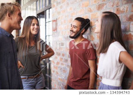 Happy, friends and students talking together in a hallway for discussion, learning or a chat. Diversity group of women and men at campus or university to talk about education, project or school work 134394743