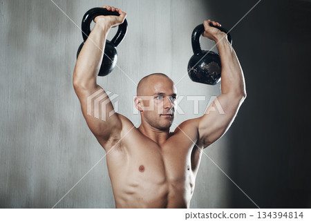 Fitness, man and weightlifting with kettlebell for arm workout or intense exercise at the gym. Serious muscular male lifting weight for strong exercising, power or strength training in bodybuilding 134394814