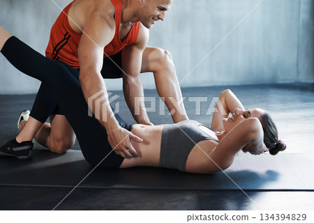 Gym, people and personal trainer coaching woman with floor sit up, fitness performance or teamwork core exercise. Health club workout, training partner and team coach helping person with challenge 134394829