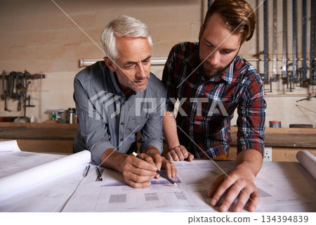 Architect team, working on blueprint in workshop and designer for engineering collaboration. Senior in architecture with male trainee, work on remodeling project with floor plan paperwork and drawing Architect team, working on blueprint in workshop and designer for engineering collaboration. Senior in architecture with male trainee, work on remodeling project with floor plan paperwork and drawing 134394839