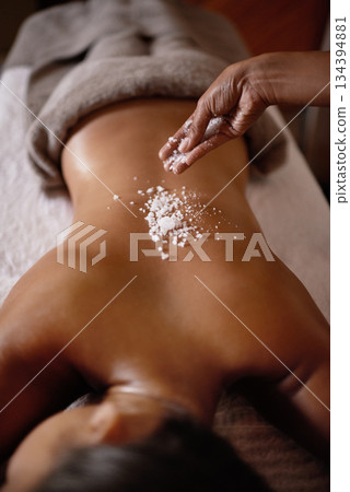 Salt sprinkle, back scrub and spa specialist hands with woman customer at a hotel with massage. Exfoliate therapy, luxury and relax treatment of a female person rest for skincare and wellness 134394881