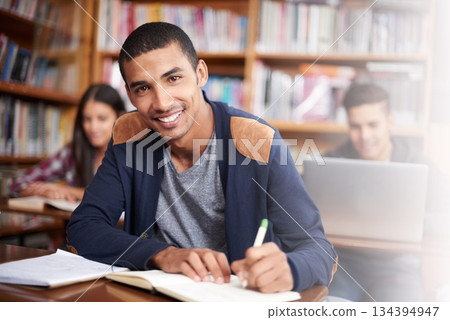 Study, writing and library with portrait of man for education, research and classroom quiz. Smile, learning and notebook with male student on university campus for knowledge, scholarship and project 134394947