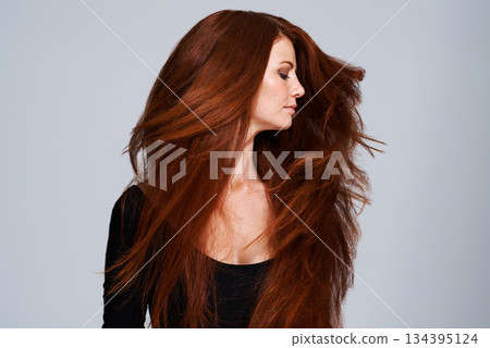 Red hair, shake and woman in studio for keratin treatment, wellness and haircare on gray background. Beauty, hairdresser mockup and female model with shine, healthy and natural, ginger hairstyle 134395124