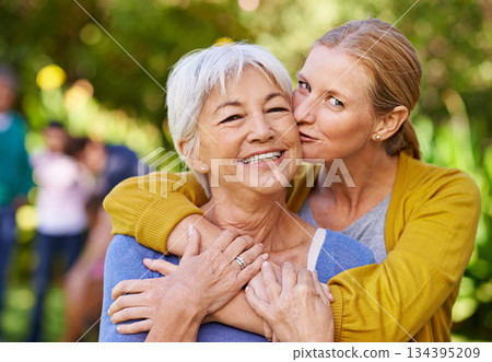 Senior mother, woman and kiss in nature, outdoor and portrait with love, care and trees on holiday. Elderly mama, lady and embrace with bond, excited face and support in backyard with summer sunshine 134395209