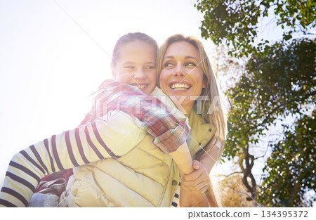 Hug, piggyback and happy kid, mom or free people enjoy family time, freedom and wellness on bonding walk. Sky, sun flare and youth girl with mother, mama or woman smile for outdoor fun on Mothers Day 134395372