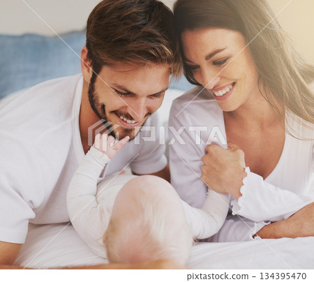 Happy family of mother, father and baby in bedroom for love, care and quality time together. Parents, newborn kid and relax on bed with smile, childhood development and support to nurture at home 134395470