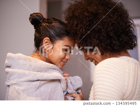 Mother, child in bath towel and close for love, bonding and hugging after cleaning, shower and routine in a bathroom. Washing, embrace and mom with girl, loving and care after a bath in their home 134395495