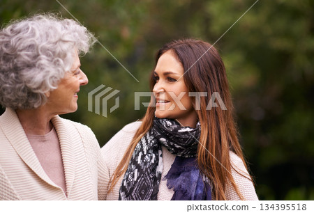 Talking, outdoor and woman with elderly mother together on a nature vacation or holiday bonding in happiness. Retirement, women and young happy female person in conversation and with mom in a garden Talking, outdoor and woman with elderly mother together on a nature vacation or holiday bonding in happiness. Retirement, women and young happy female person in conversation and with mom in a garden 134395518
