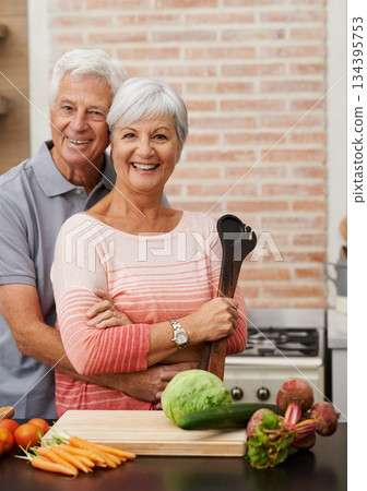 Cooking, happy and portrait of old couple in kitchen for salad, love and nutrition. Health, smile and retirement with senior man and woman cutting vegetables at home for food, dinner and recipe 134395753