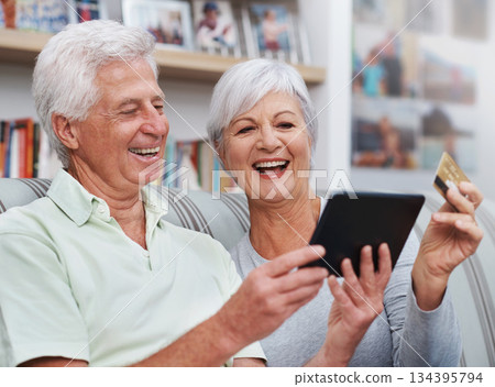 Excited senior couple, tablet and credit card for online shopping on living room sofa together at home. Happy elderly man and woman smiling on technology in ecommerce, sale or payment on lounge couch Excited senior couple, tablet and credit card for online shopping on living room sofa together at home. Happy elderly man and woman smiling on technology in ecommerce, sale or payment on lounge couch 134395794