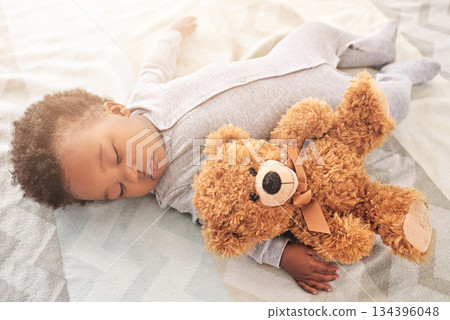 Sleeping, teddy bear and toy with baby in bedroom for carefree, development and innocence. Dreaming, relax and comfortable with african infant in nursery at home for morning, resting and bedtime 134396048