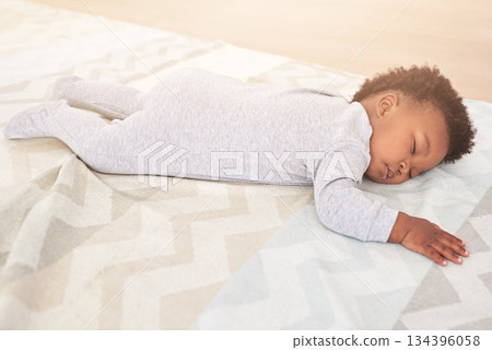 Bedroom, cute and baby sleeping in home on blanket for rest, nap time and dreaming in nursery. Childcare, newborn and cute, tired and African child in bed sleep for comfortable, relaxing and calm 134396058