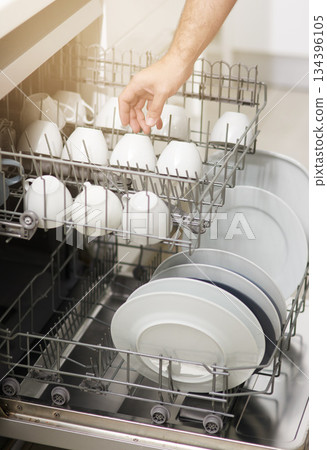 Dishwasher machine, cleaning and hands of person washing dirty kitchenware for easy housekeeping, hygiene and housework. Closeup of electrical appliance for dishes, cups and plates in kitchen at home Dishwasher machine, cleaning and hands of person washing dirty kitchenware for easy housekeeping, hygiene and housework. Closeup of electrical appliance for dishes, cups and plates in kitchen at home 134396105