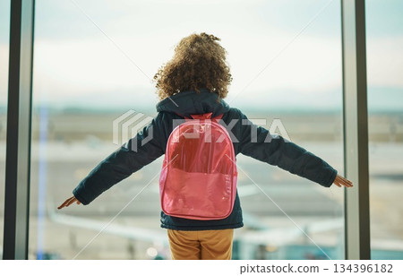 Girl kid, looking and airport window for greeting, goodbye and flying on airplane, international transport or travel. Child, back and watch takeoff by glass for global immigration, young and playing 134396182