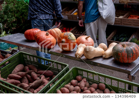 Open air farmers market with fresh produce stalls. potatoes, sweet potatoes, pumpkins 134396409