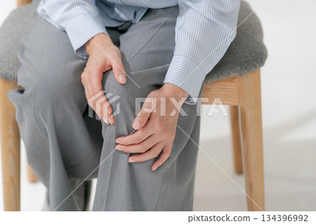 Woman holding her knees Woman holding her knees 134396992
