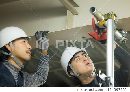 工人們在工廠工地組裝單管管道 工人們在工廠工地組裝單管管道 134397331