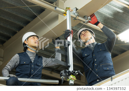 工人們在工廠工地組裝單管管道 工人們在工廠工地組裝單管管道 134397332